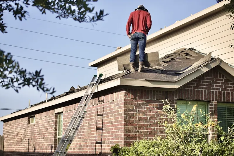 Professional roofer working on a residential roof in Farmington